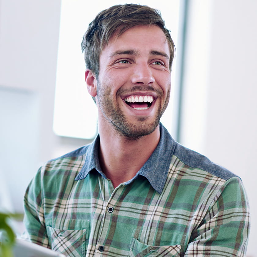 Smiling man with a beard wearing a plaid shirt