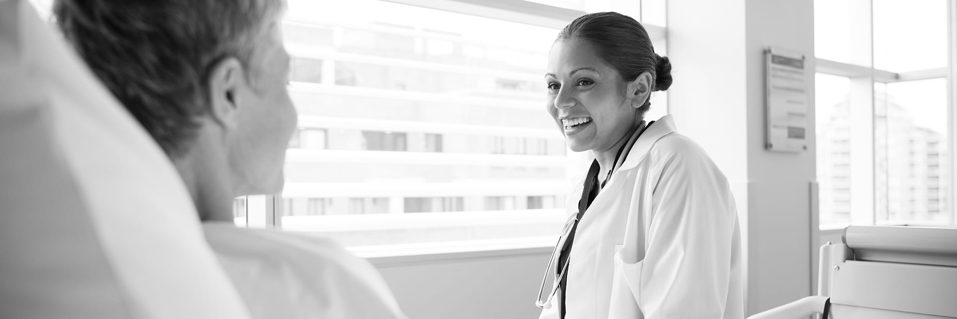 Doctor talking to a patient who is lying on a bed