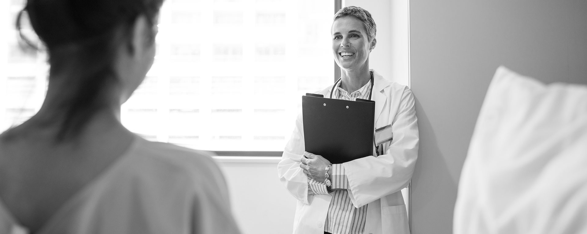 Doctor talking to a patient while holding a clipboard